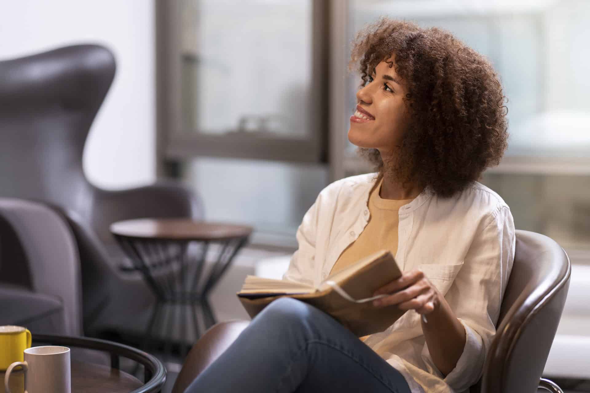 woman looking up from reading one of the books by School of Evangelism