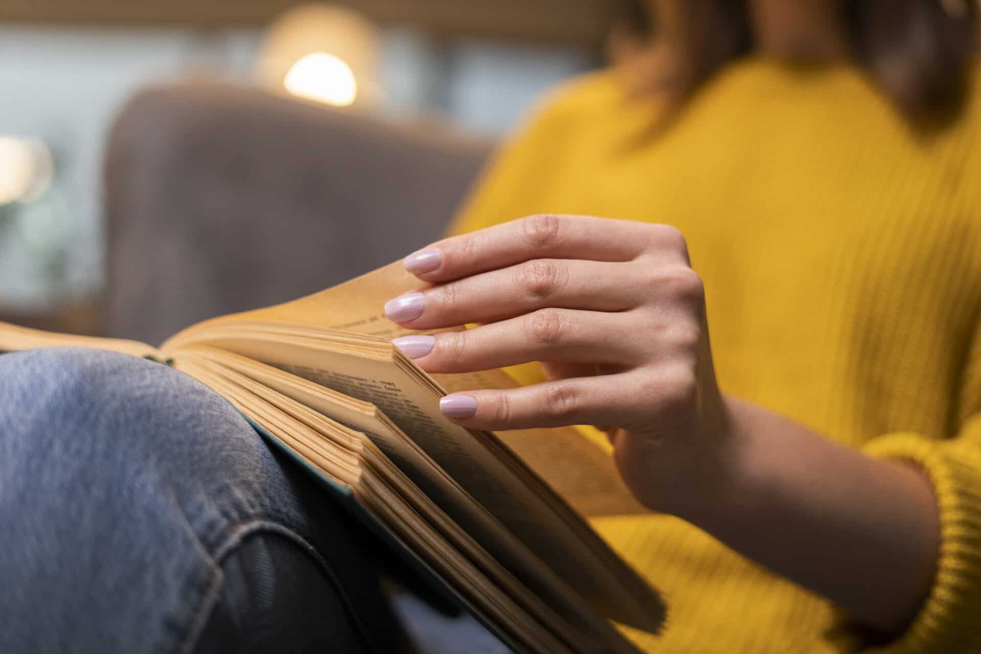 close up of a woman's hand turning book pages